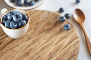 Blueberries in a mug on the table. Copy space