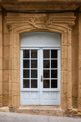 Old wooden door in a beautiful stone facade