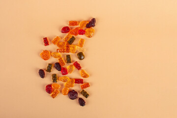 Fruit flavored worm shape, jelly candies. Isolated on cream background.