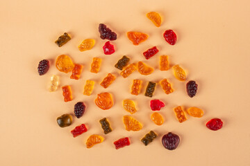Fruit flavored worm shape, jelly candies. Isolated on cream background.