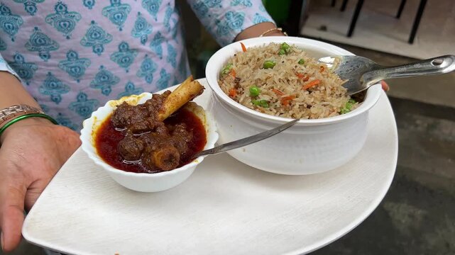 Bihari style mutton nalli and fried rice held by a girl. No face video