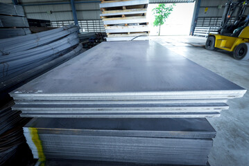 Construction Materials Metals black steel sheet, stainless steel sheet stacked arranged in factory.iron steel store in warehouse heavy industry.