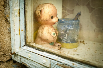 Creepy stara zabawka w oknie starego domu © Rafal Kot