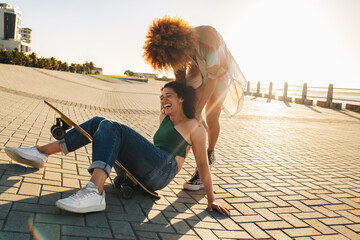 Lively young women laughing and enjoying a break from college with best friends outdoors
