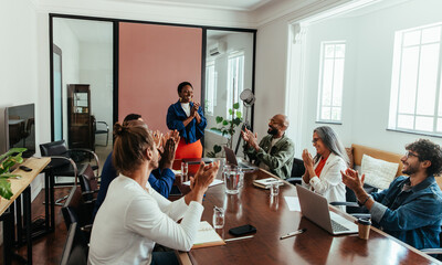 Business team celebrating during a casual office presentation in a modern boardroom