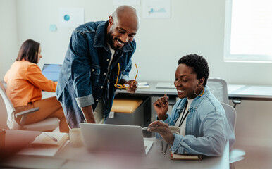 Manager giving feedback and collaborating with an employee during a review discussion in a modern office