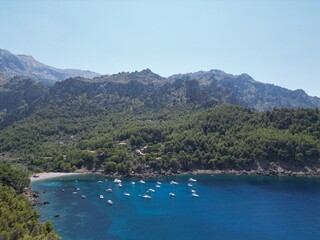 Obraz premium Cala Tuent Bay with Yachts Anchored in Mallorca's Serene Mountainous Coastline