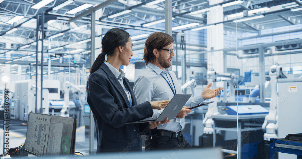 Poster Male Engineer and Female Project Manager Standing in Office, Talking, Using Computers and Monitoring Production at a Modern Automated Electronics Manufacture with AI Robotic Arms