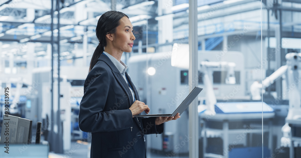 Aufkleber Production Line Technician Working on a Laptop Computer at Factory Office. Asian Female Software Specialist Updating Code for Machine Production and Assembly with Automated Robotic Arms