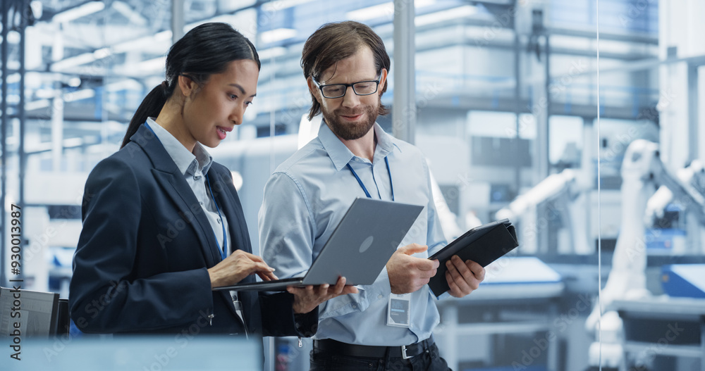 Leinwandbilder industrial engineers working at technology factory. caucasian man and asian female using laptop and 