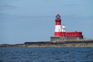 A Red and White Sea Lighthouse and Keepers Building.