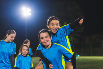 football player little girls in blue uniforms having fun before practice in a stadium at night. High quality photo