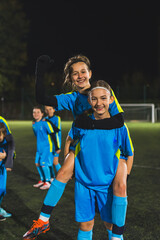 vertical shot of a cheerful and happy football player little girls celebrating victory. High quality photo