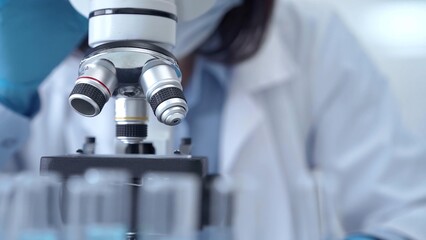 Scientist using microscope in laboratory. Close-up of a researcher's hands adjusting a modern microscope in a lab setting
