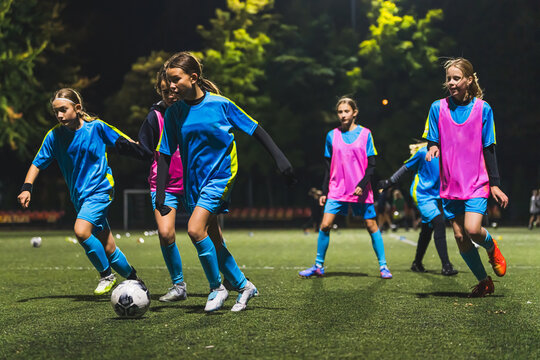 little soccer player girls performing an action play on a soccer stadium. Girls in uniforms playing soccer . High quality photo