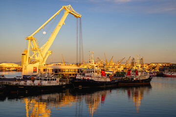 Fototapeta premium cranes in harbor at the waterfront of cape town south africa during full moon