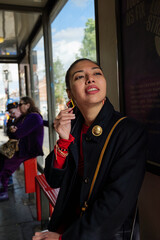 London - 06 11 2022: Girl at the bus stop touches an earring