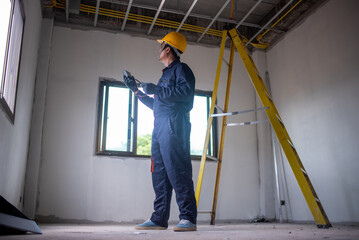 Fototapeta premium An electrician is wiring the house Electrician Working on Electrical Wiring in a New Construction