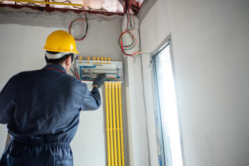 An electrician is wiring the house Electrician Working on Electrical Wiring in a New Construction