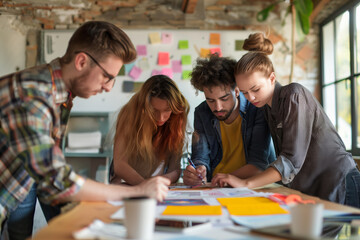 Obraz premium Unposed group of creative business people in an open concept office brainstorming their next project.