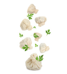 Delicious khinkali (Georgian dumplings) and parsley falling on white background