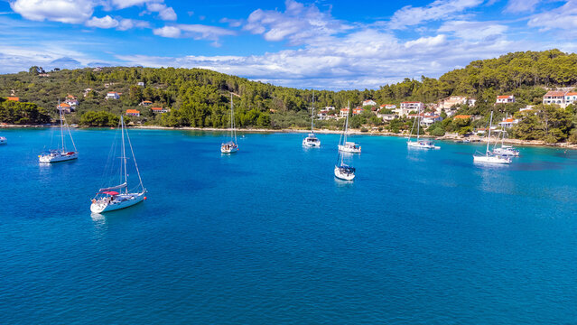 Drone view of yachts moored on buoys near the shore in the bay of Uvala Gradina near the town of Vela Luka on the island of Korcula in Croatia