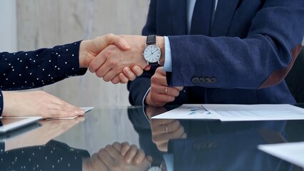 Professional handshake between two professionals and applauds at a corporate meeting with reflection on table over a business meeting. Business people concept