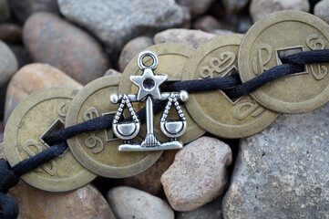 A metal statuette of scales and Chinese coins. Zodiac signs.