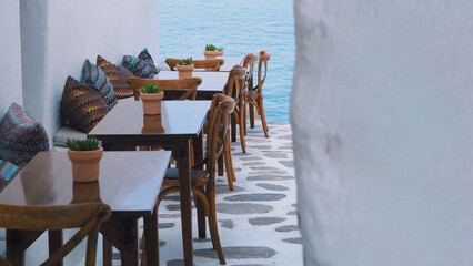 Narrow alley with row of tables in Mykonos.