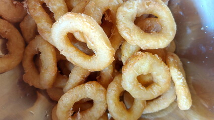 Calamari rings in deep frying in pan. Close up of frying onion rings in the fryer in hot oil.