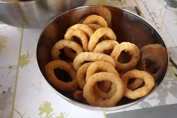 Calamari rings in deep frying in pan. Close up of frying onion rings in the fryer in hot oil.