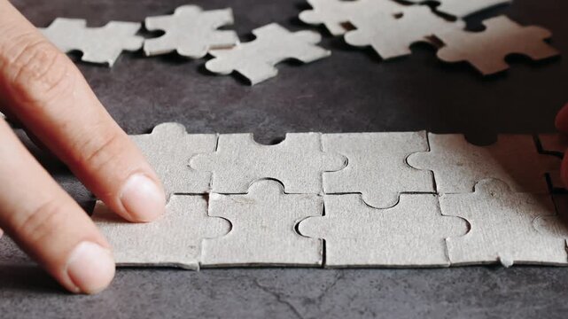 Close up hand holding pieces of jigsaw puzzle, Business solutions, success and strategy concept.