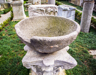 view of stone fountain and artifacs  in istanbul archeology museum garden