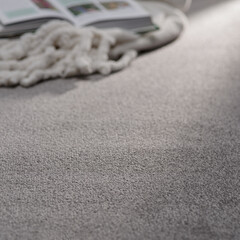 Cozy Reading Nook with Open Book and Soft Knit Blanket on Light Gray Carpet