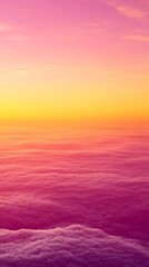 Fototapeta premium A breathtaking view of a colorful sunset over a sea of clouds, painted with shades of pink, yellow, and orange.