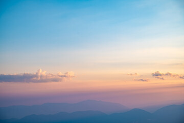Beautiful clouds at sunset over mountains, rays of sunshine, beautiful light, natural background, calm and tranquility