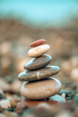 A pyramid of stones on a pebble beach by the sea, the concept of balance, balance, tranquility, relaxation
