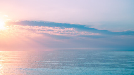 Fototapeta premium Beautiful gentle and delicate pink sunrise on the sea, sky with clouds, natural delicate background