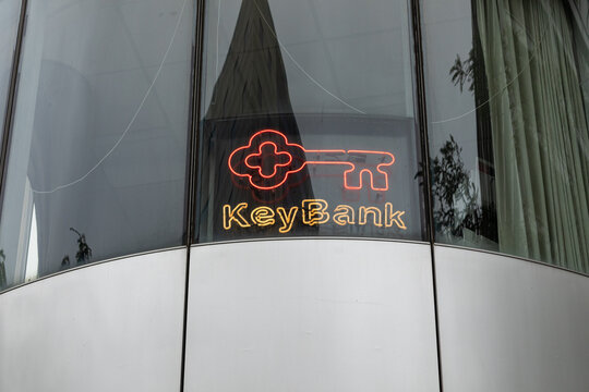 Portland, OR, USA - Aug 12, 2024 - Key Bank logo and emblem behind the window of the bank building captured from the street
