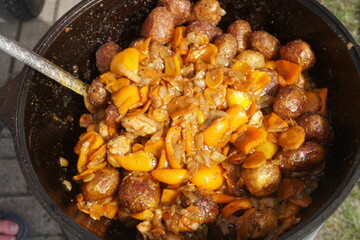 Vegetables are fried in a pan on the stove. Pan-fried carrots with vegetables