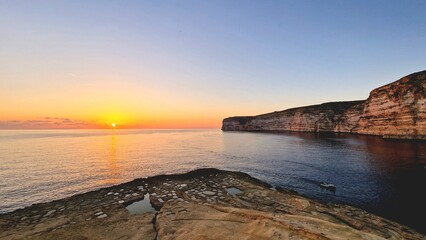 Sunset Over Xlendi Cliffs, Gozo, Malta: A Serene Coastal Landscape