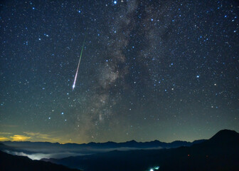 北アルプスの夜空に横たわる天の川と流れ星