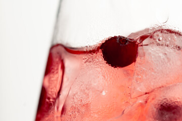 Fototapeta premium macro frame of glasses with cool red cocktail ice cubes condensation and drops on the glass fruity red balls