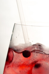 Fototapeta premium macro frame of glasses with cool red cocktail ice cubes condensation and drops on the glass fruity red balls