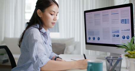 Smart Gen Z tech talent workforce typing SEO sale report on desktop PC happy work easy relax at home office. Remote WFH reskill upskill job MBA study of young people asia woman examine big data graph.