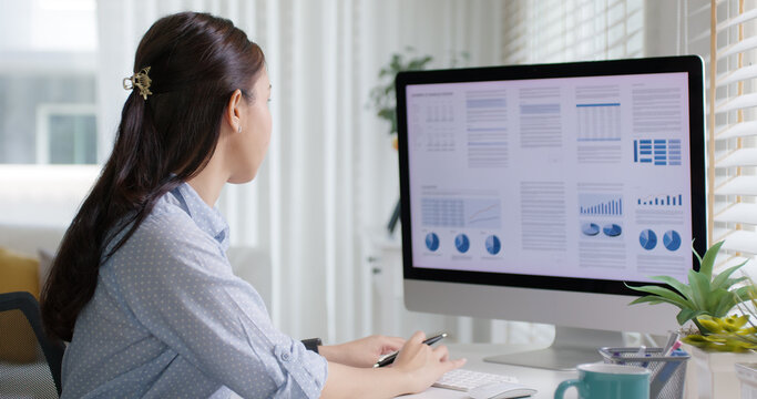 Smart Gen Z tech talent workforce typing SEO sale report on desktop PC happy work easy relax at home office. Remote WFH reskill upskill job MBA study of young people asia woman examine big data graph.