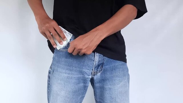 Businessman placing money into his pocket.