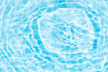 Blue water with ripples on the surface. Defocus blurred transparent blue colored clear calm water surface texture with splashes and bubbles. Water waves with shining pattern texture background.