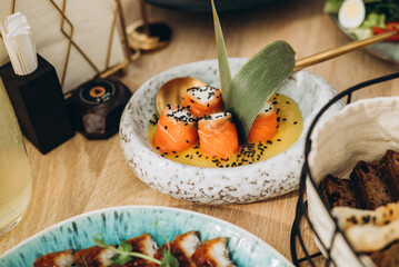 A festive and beautifully decorated wedding table. Decorated with flowers.various bottles of drinks, beautiful dishes, salads and sliced meat rolls.vegetable slicing.