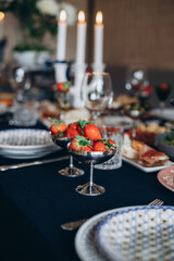 A festive and beautifully decorated wedding table. Decorated with flowers.various bottles of drinks, beautiful dishes, salads and sliced meat rolls.vegetable slicing.